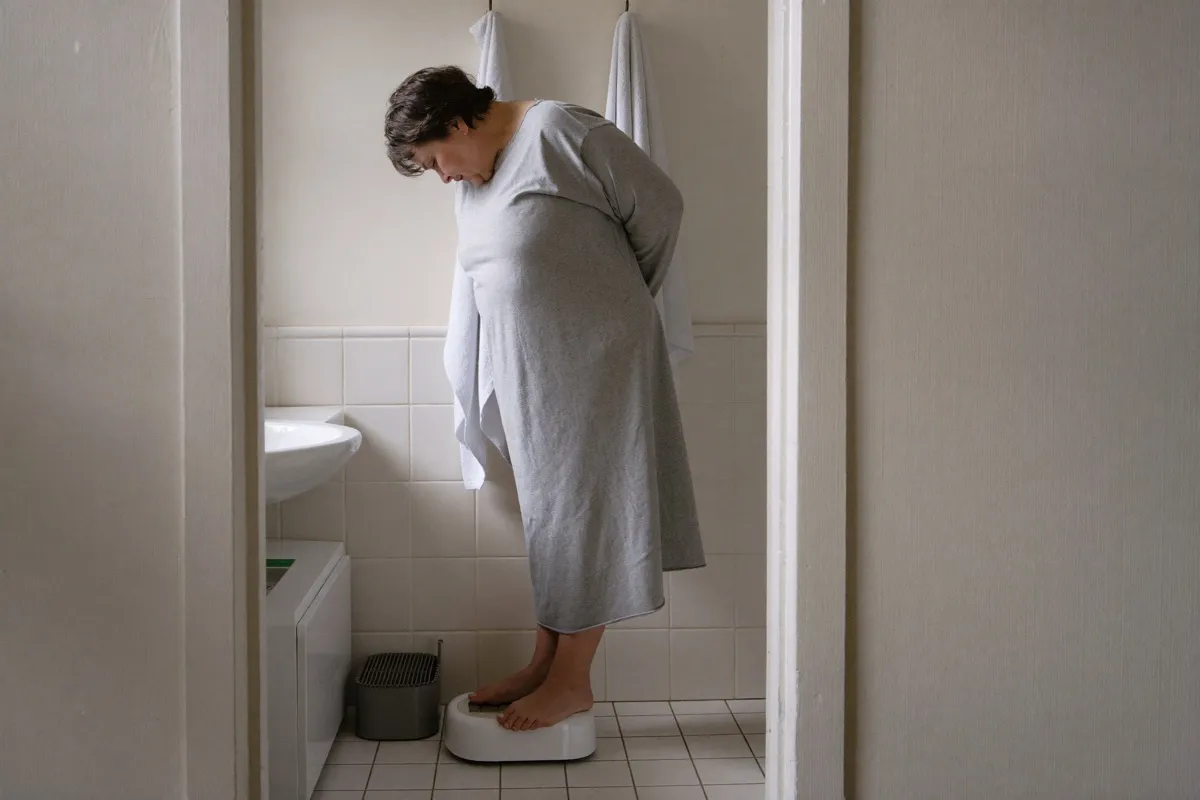 Frau steht auf der Waage im Bad