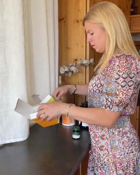 Frau nimmt morgens in der Küche ihre Presslinge