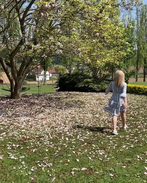 Frau geht entspannt durch einen Park