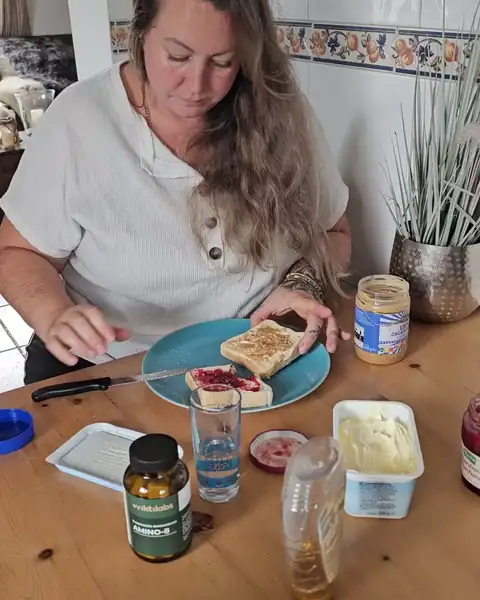 Frau isst am Küchentisch, der Appetit ist zurück