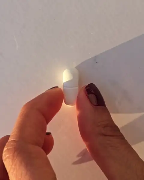 Ein Pressling zwischen zwei Fingern, ganz nah