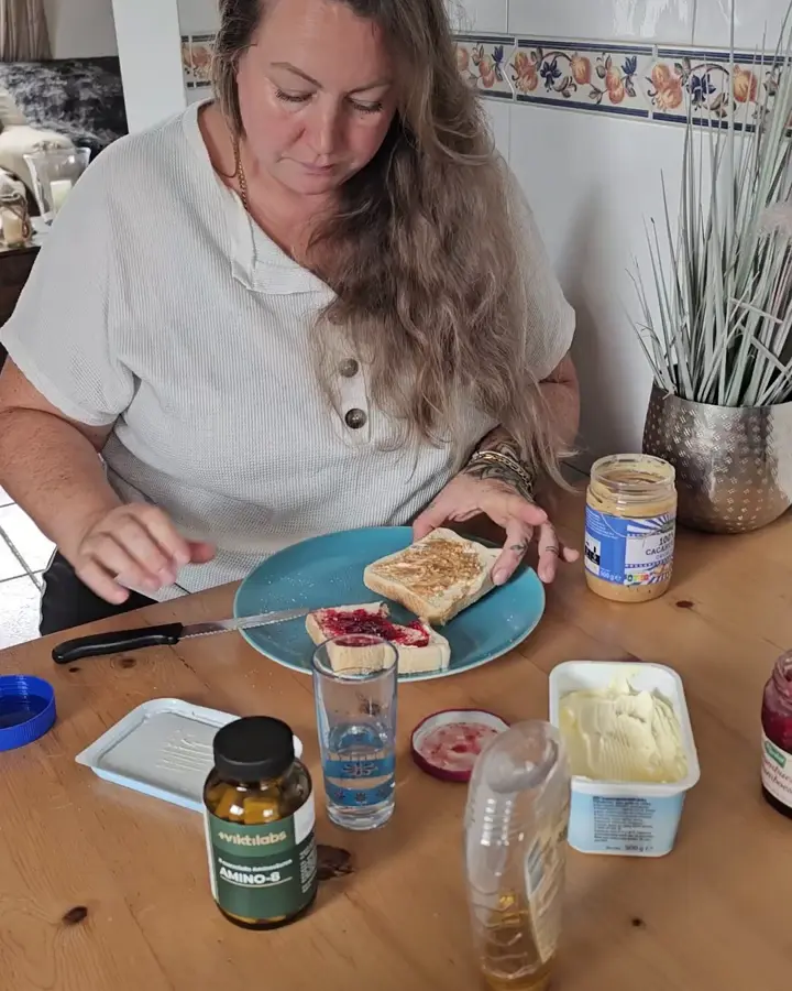 Frau isst am Küchentisch, der Appetit ist zurück