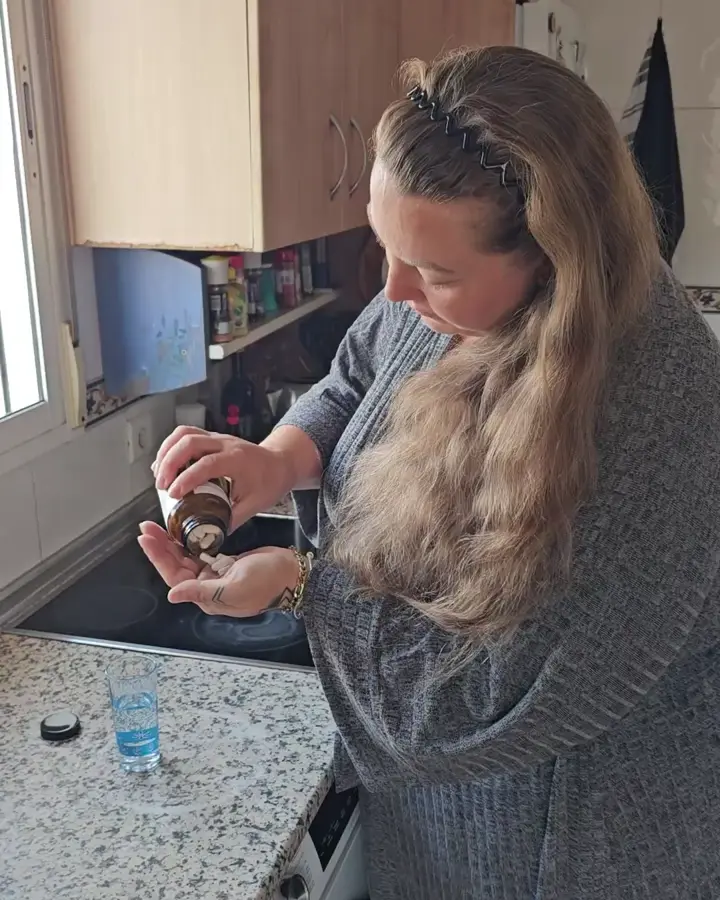 Frau in der Küche mit einem Glas Wasser