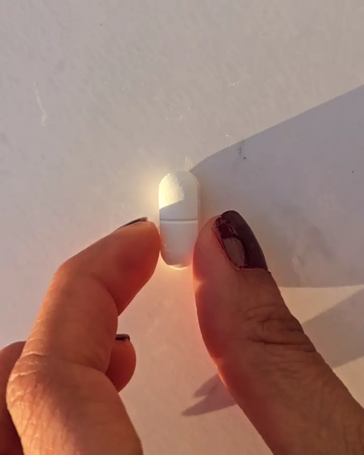 Ein Pressling zwischen zwei Fingern, ganz nah