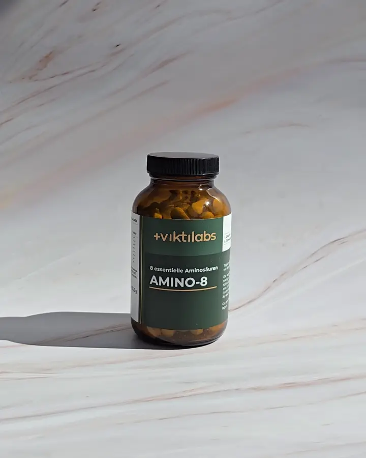 Ein Glas Amino-8 von Viktilabs auf hellem Stein